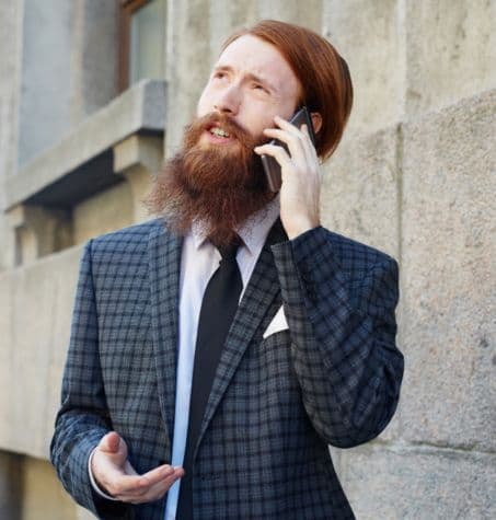 A well-dressed CEO or investor in a corporate setting, wearing a tailored suit has a well-groomed neckbeard