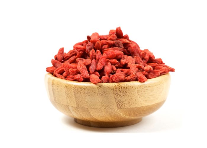 a bowl of goji berries against a white background