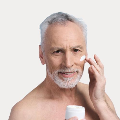 mature guy applying moisturiser to his face