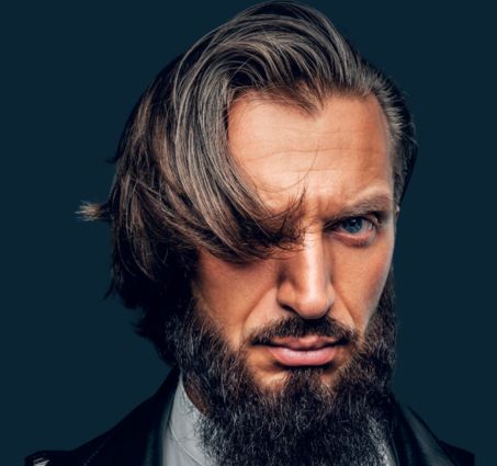 strong featured man with long comb over covering one eye