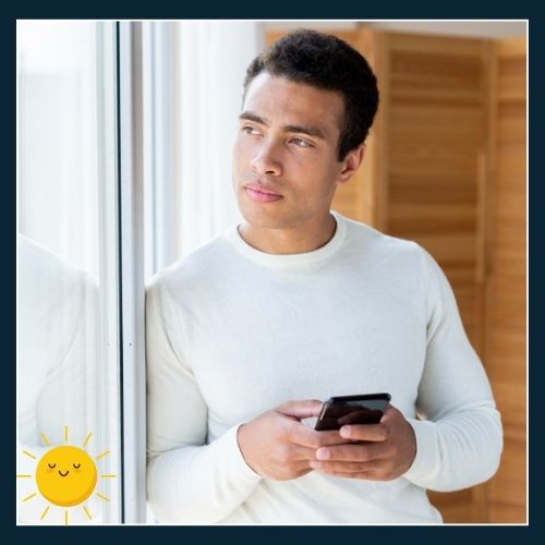 a man standing by a window with soft daylight streaming in. a small sun icon appears near the window to indicate natural light.
