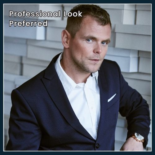 High-quality photo of a clean-shaven man in a blue business suit, confidently posing over white artistic wall made from bricks, with overlay text 'Professional Look Preferred.