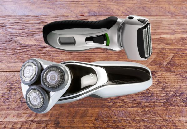 two sleek black and silver beard shavers: one rotary and one foil against a plain brown wood background