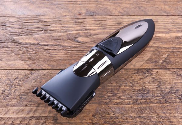 a sleek black beard trimmer against a plain brown wood background