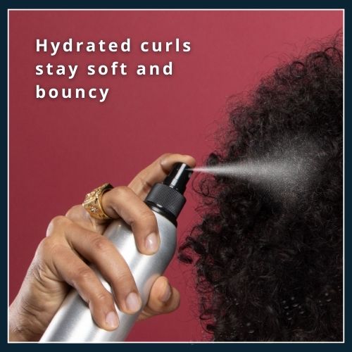 Close-up of curly hair with visible water droplets and icons of an aloe vera leaf and a coconut oil droplet, illustrating deep hydration for curls.