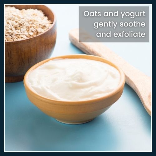 Flat-lay of a bowl containing ground oats mixed with plain yogurt and a wooden spoon, illustrating a gentle DIY exfoliant for sensitive or dry skin.