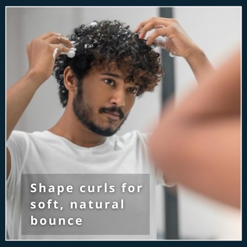 Close-up of curly hair being styled with curl cream and a drop of serum, illustrating how to shape and define curls for soft, bouncy results