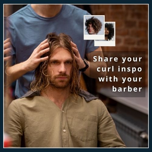 Client showing a barber curly-hair inspiration photos on a smartphone in a barbershop, illustrating the importance of clear communication for a custom cut.