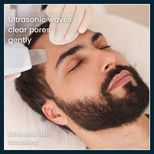 Close-up of an ultrasonic spatula device gliding over a male client’s cheek to gently remove dead skin and clear pores, illustrating ultrasonic skin scrubbing