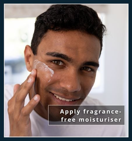 a man standing in the bathroom in front of the mirror is moisturising his face with a fragrance free moisturiser. This illustrates moisturising the treated area of the skin after hair removal treatment.