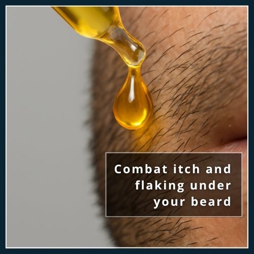 Golden jojoba oil drop falling onto short stubble and skin to hydrate and calm irritation