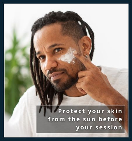 A man with richly-pigmented skin man applying sunscreen to his neck at home before a hair removal appointment.