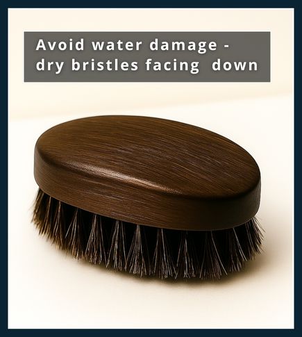 Boar-bristle beard brush resting bristles-down on a folded towel, propped by a small wooden block