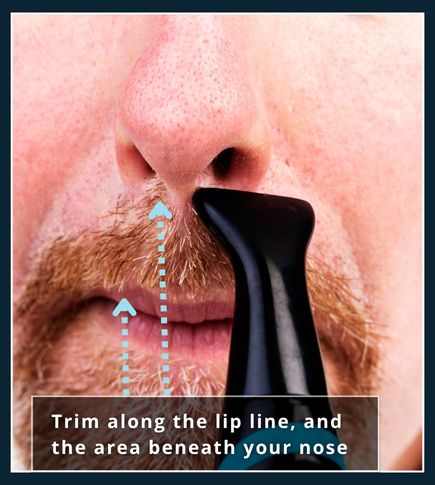 Man trimming moustache overhang with a small‑guard trimmer