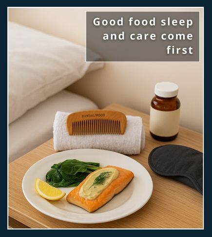 Plate with salmon, greens, and a lemon wedge on a bedside table, alongside a sandalwood beard comb on a rolled towel, a sleep mask, and a small MSM supplement bottle, showing that MSM works best when diet, rest, and daily care are in place.