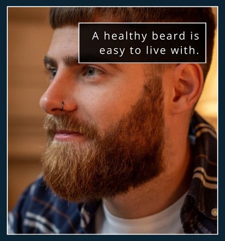 A man with a tidy, well-kept beard sitting comfortably, not touching or adjusting it.