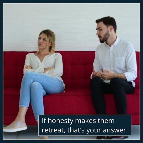 A man speaks calmly while his partner looks away, illustrating the moment of recognising emotional unavailability.