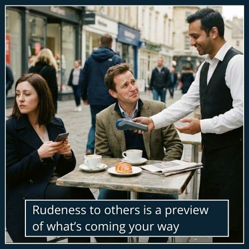 A man sits at a café table looking uncomfortable while a woman beside him dismisses a polite waiter offering a card reader, showing clear tension and rudeness toward service staff.