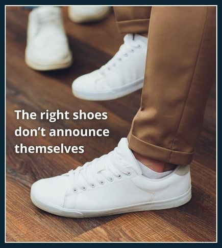 Low profile white trainers with clean lines worn in a modern indoor setting suitable for gym and everyday wear