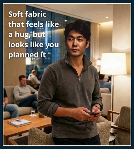 Man wearing a plain quarter-zip top with rolled sleeves in a modern lounge setting suitable for post-workout social time