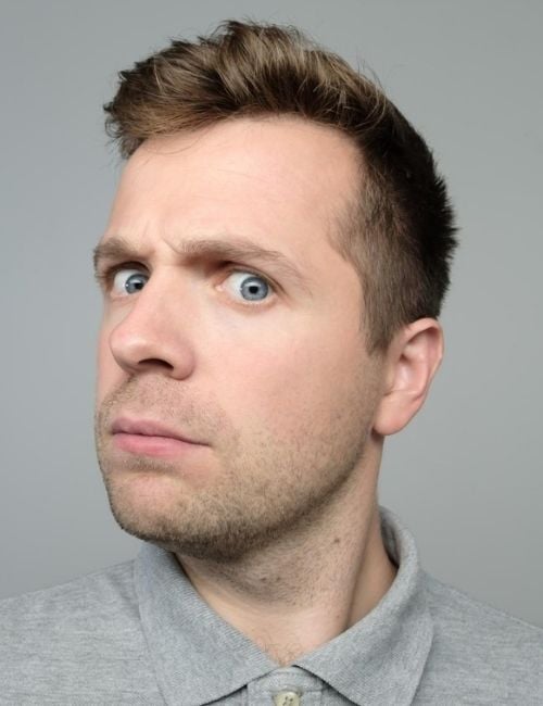 A man checking his profile and seems baffled about having a double chin that doesn't fit his physique.