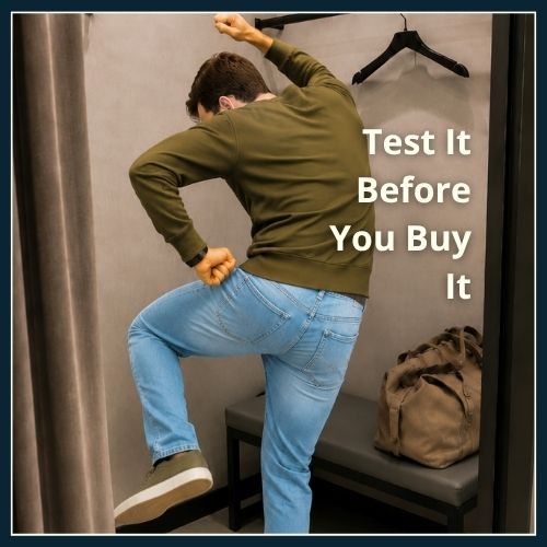 Man testing the fit and stretch of clothes in the changing room of clothing store, before he buys.