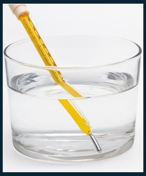Glass thermometer checking the temperature of water before handwashing a T-shirt