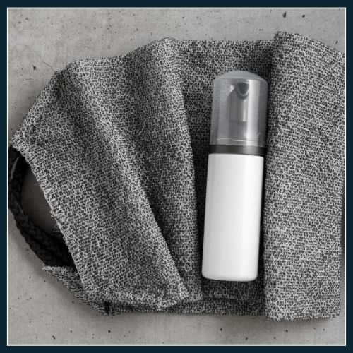 flat lay of grey towel and roll on deodorant for men